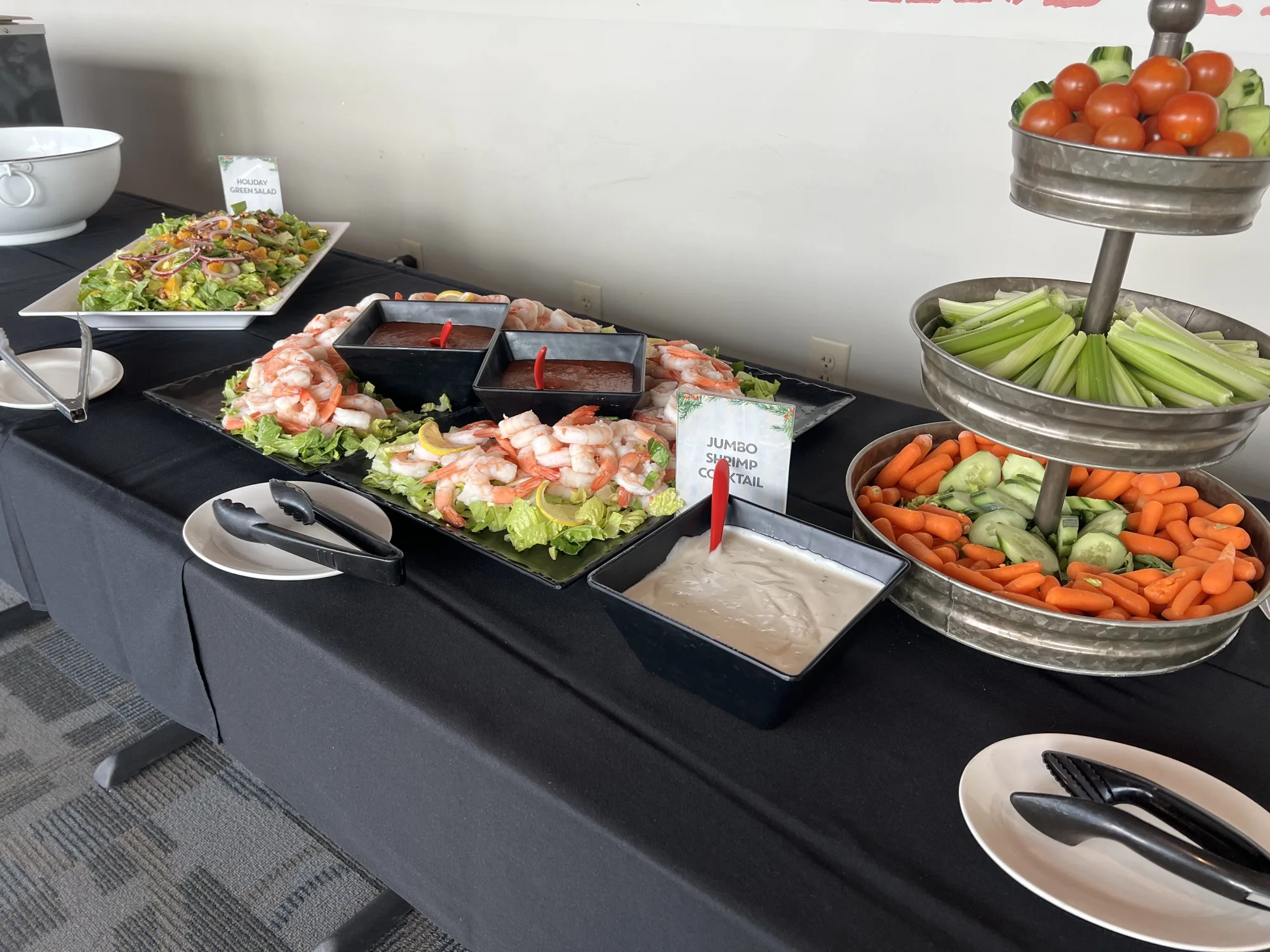 Shrimp cocktail, salad and fresh vegetables displayed for a private event