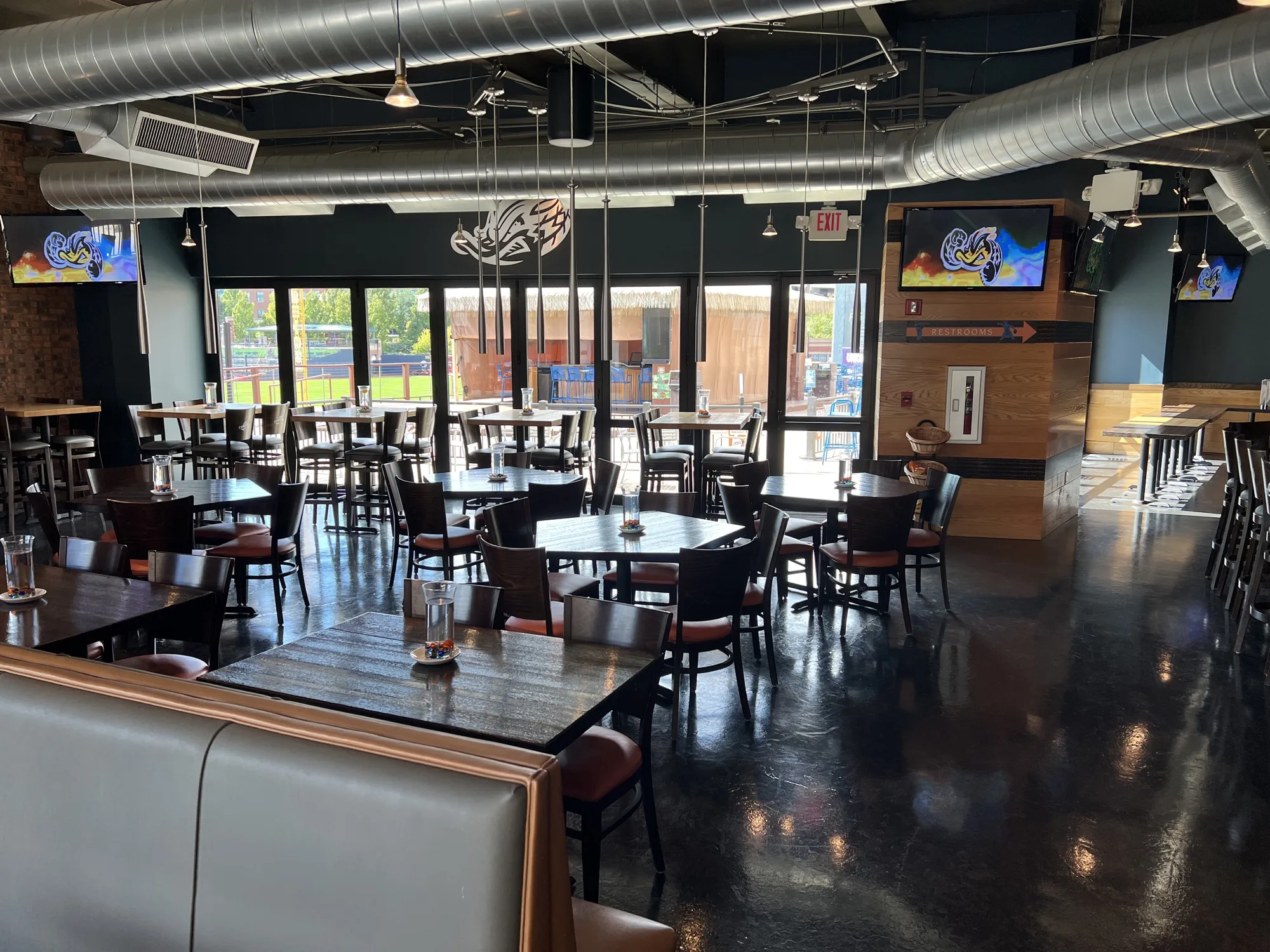 Kaulig Companies Championship Club arranged with high-top and dining tables beside the patio