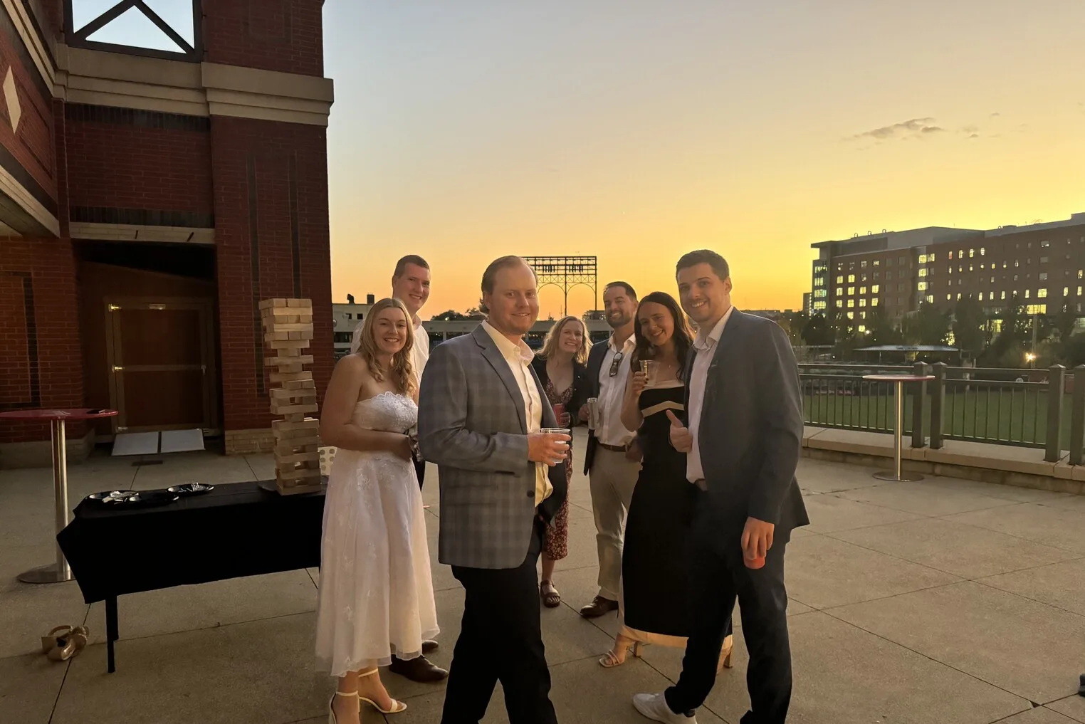 A wedding party gathering on the Duck Club patio at sunset