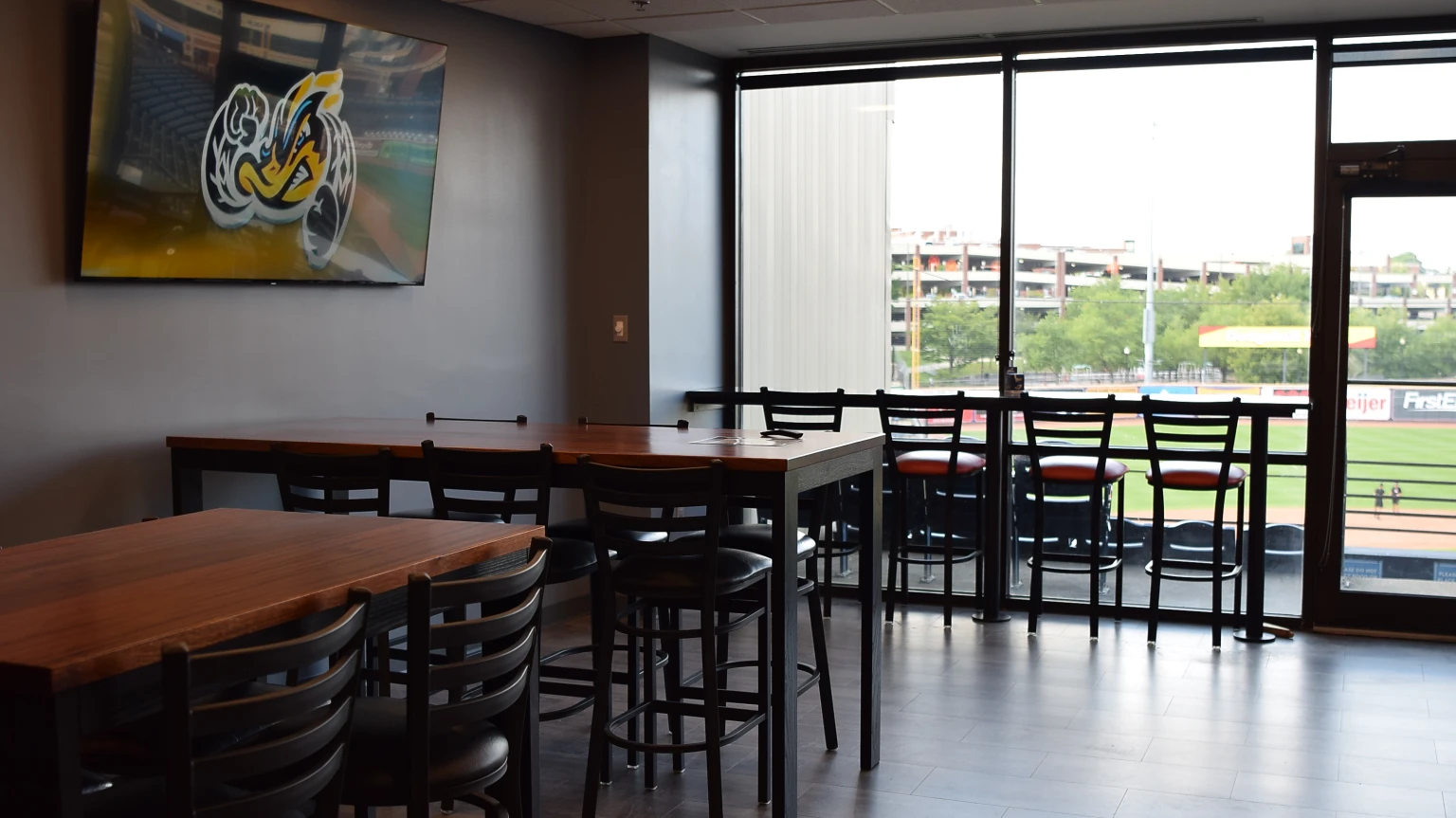 Private suite interior with tables, televisions and a view overlooking the field