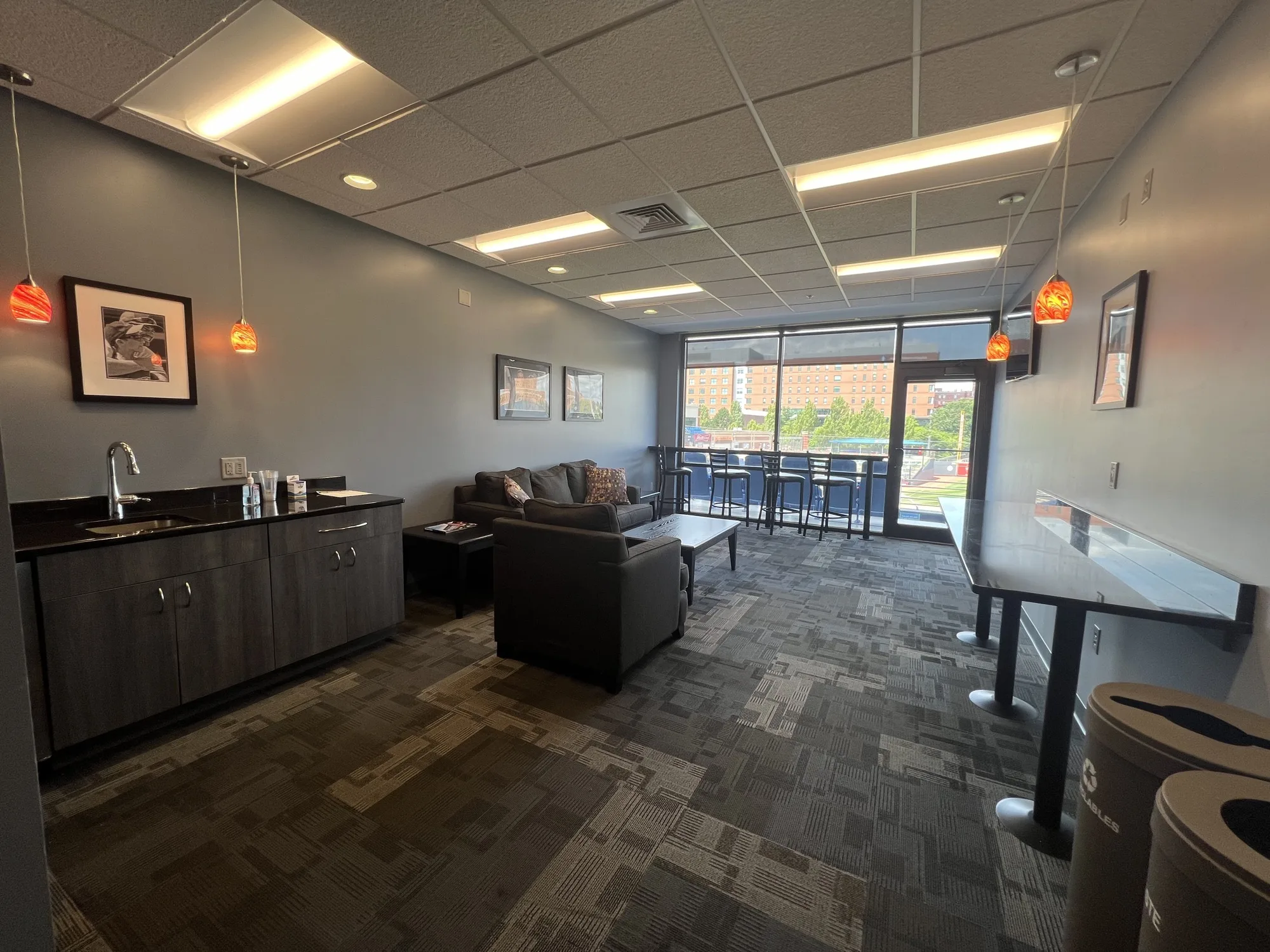 Private suite with lounge seating, wet bar, high-top seating and a balcony overlooking the field
